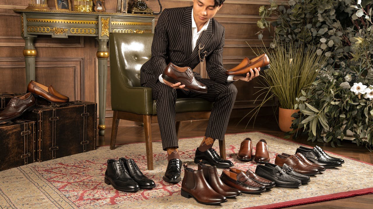 elegant mam sitting and looking at luxury derby shoes