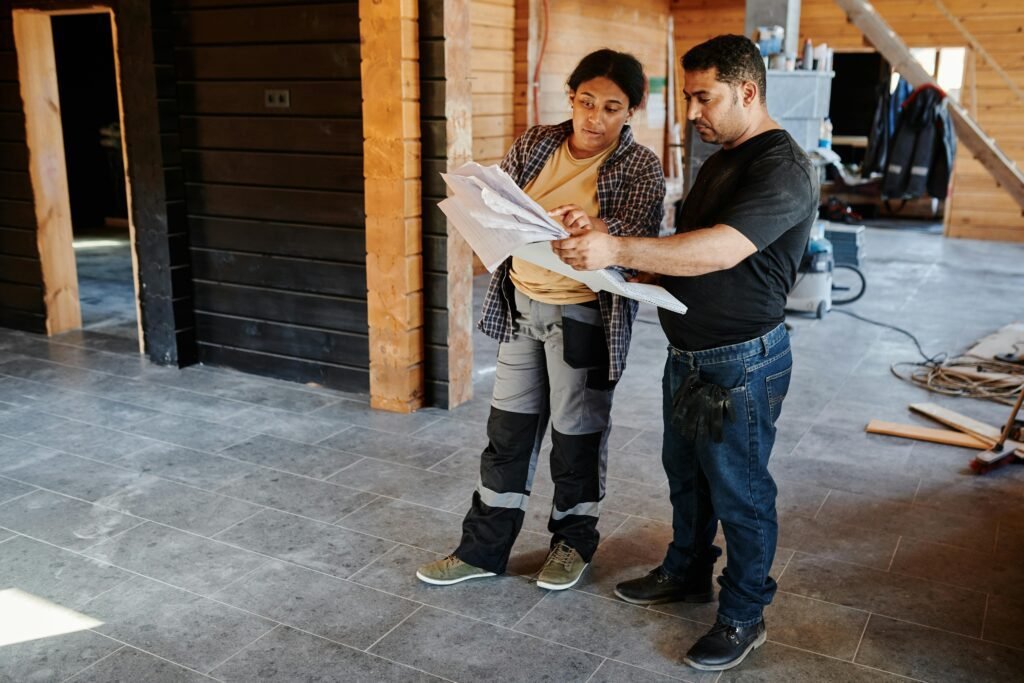 a-man-and-a-woman-holding-a-paper-while-standing-on-the-tiled-wall