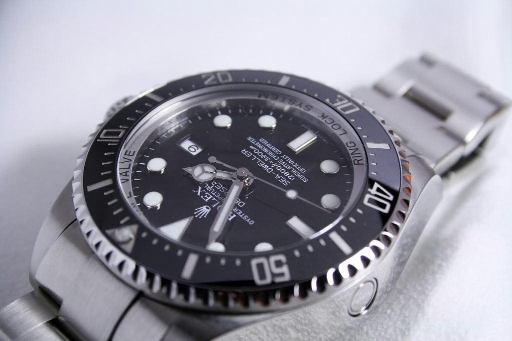 Close-up view of a luxury Rolex Sea-Dweller watch with a black dial, luminous markers, and a stainless steel bracelet, featured on Pump It Up Magazine to showcase timeless elegance and superior craftsmanship.